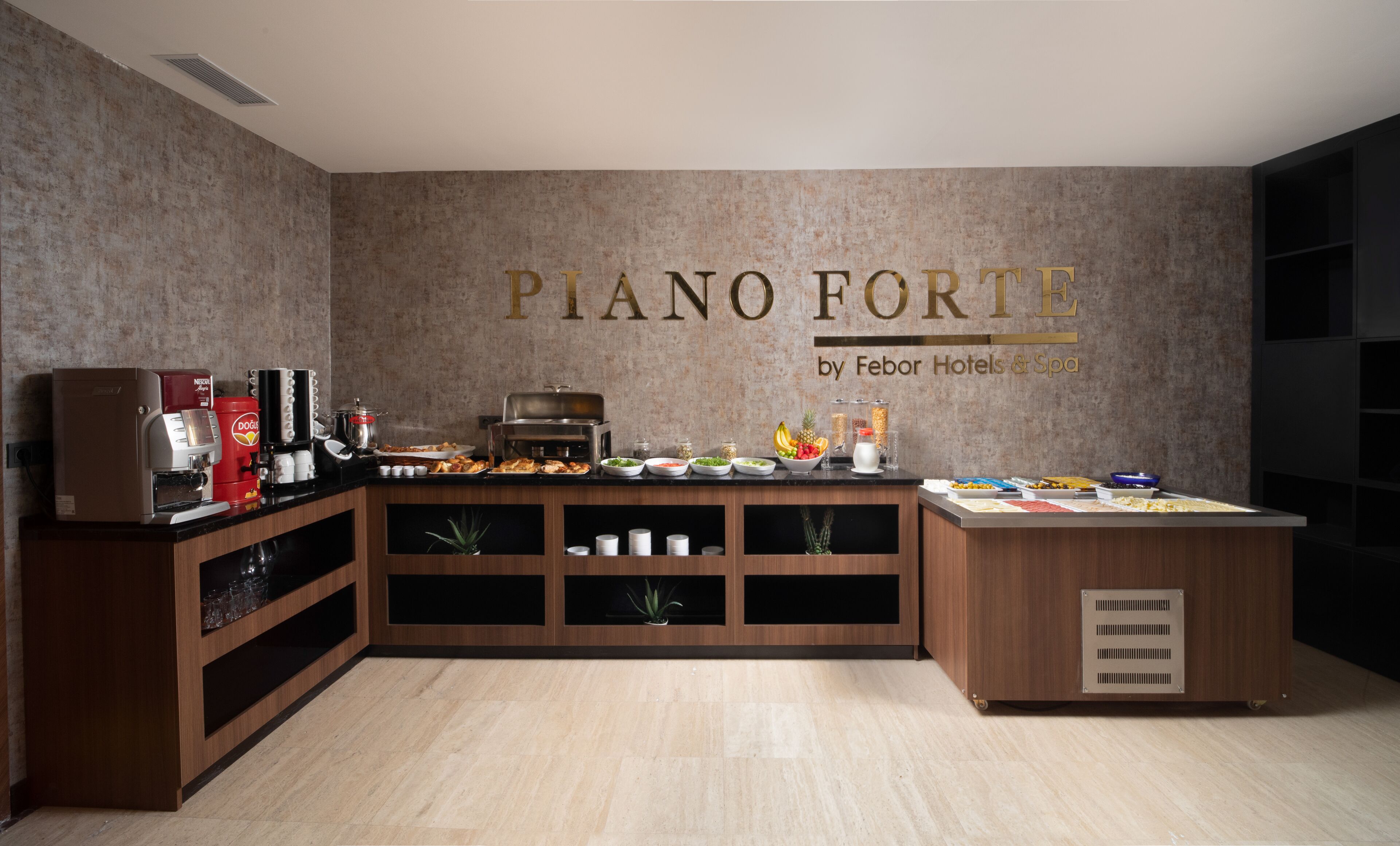 Un espace buffet comprenant un coin café, une variété de plats et un panneau mural indiquant : « Piano Forte, par Febor Hotels & Spa ».