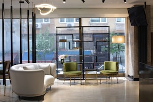 A modern interior with a sofa, two armchairs, a table, and a lamp.