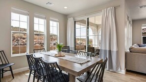 A dining area with a wooden table and chairs, large windows with curtains, and a view of a rocky landscape. - VACATION STATION, PICKLEBALL, KAYAKS, WIGGLECARS, PING PONG, FOOSBALL, BBQ (Washington)