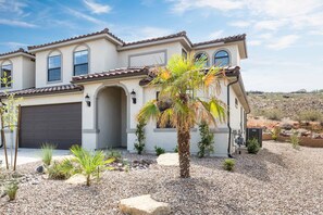 A two-story house with a garage, arched windows, and a landscaped garden with rocks and small plants. - VACATION STATION, PICKLEBALL, KAYAKS, WIGGLECARS, PING PONG, FOOSBALL, BBQ (Washington)