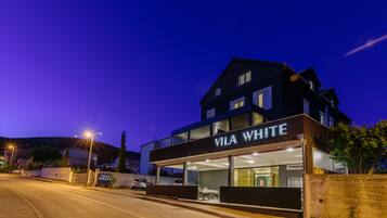 Een modern gebouw met een bord waarop 'Vila White' staat, 's nachts.