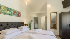Hotelkamer met een groot bed, een hoofdeinde, een schilderij, een spiegel en een kledingkast.