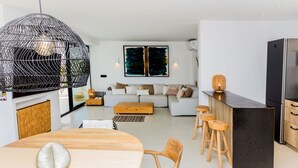 Een moderne keuken met een donker aanrecht, houten krukken en een groot eiland.