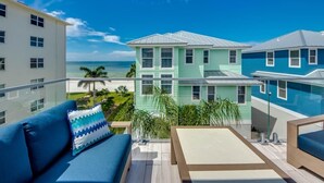 A balcony with a view of a building and the ocean.