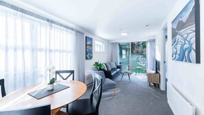 Een moderne woonkamer met een eethoek, een bank en een televisie.