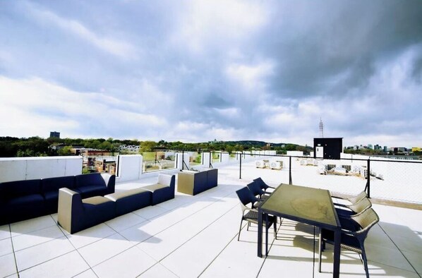 Relax on the rooftop with a long sofa, smaller sofa, and dining table for two.
