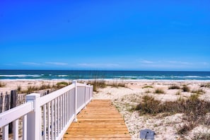 A wooden boardwalk leading to a beach with white railings. - M'Ocean Granted - Beach Front, Pet Friendly, Private Pool, Beach Gear Credit Included! (St. George Island)