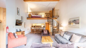 A spacious living area with a loft bedroom, a staircase, and a kitchen. - Perfect Ski-in/out condo Center Village, Free Parking, WiFi, Amazing views (Copper Mountain)