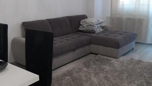 A living room with a grey sectional sofa, a white coffee table, and a grey shaggy rug. - 2 Bed-aircon-free Parking-city Centre (Chiajna)