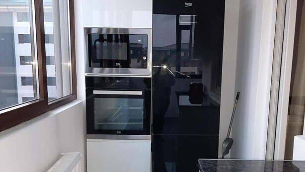 A compact kitchen with a built-in oven, microwave, and a black refrigerator. - 2 Bed-aircon-free Parking-city Centre (Chiajna)