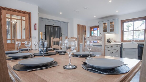 Una cucina moderna con isola in legno, elettrodomestici in acciaio inossidabile e vista sull'esterno.