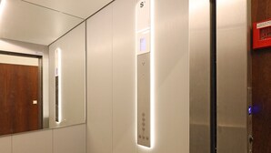 An elevator interior with a control panel, a mirror, and a door. - FLH Gaia Homey Winery Flat (Vila Nova de Gaia)