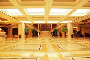 A spacious lobby with a marble floor, a grand staircase, and a large chandelier. - Xiangshui Guest Hotel (Xiangshui)