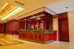 A hotel lobby with a reception desk, a large chandelier, and a check-in counter. - Xiangshui Guest Hotel (Xiangshui)