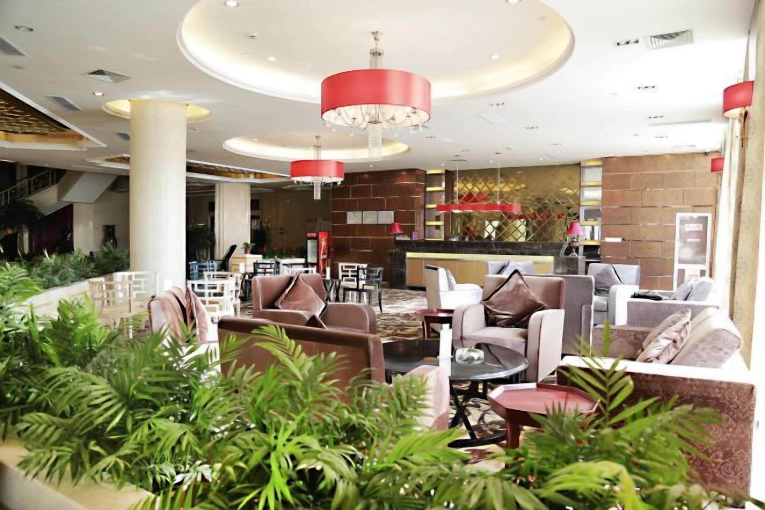 A lobby with a seating area, a reception desk, and a staircase.