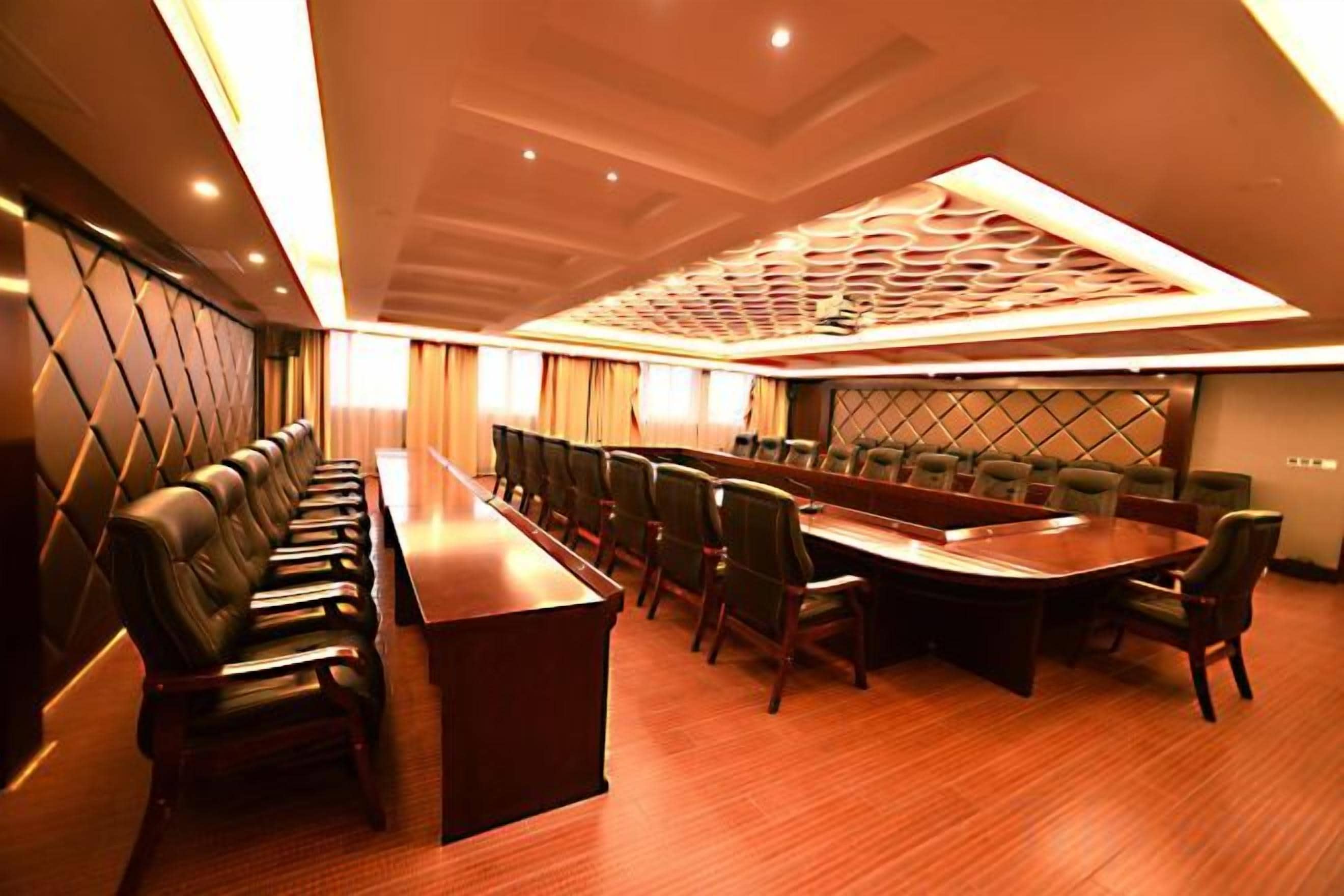 A conference room with a long table, chairs, and a patterned ceiling.