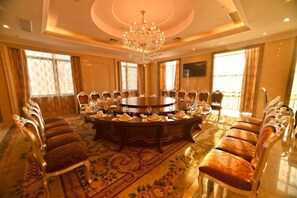 A conference room with a round table, chairs, and a chandelier. - Xiangshui Guest Hotel (Xiangshui)