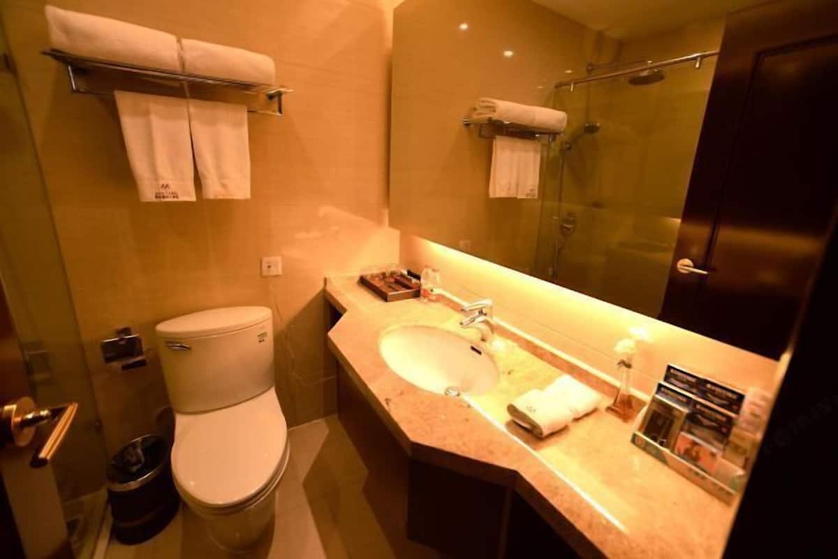 Un baño con inodoro, lavamanos y cabina de ducha de vidrio.