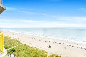 A beach with a clear view of the ocean, a yellow railing, and a pathway leading to the beach. - Bay Watch Resort 1413 - Luxury 1 Bed/1 Bath Condo - Resort Amenities (North Myrtle Beach)