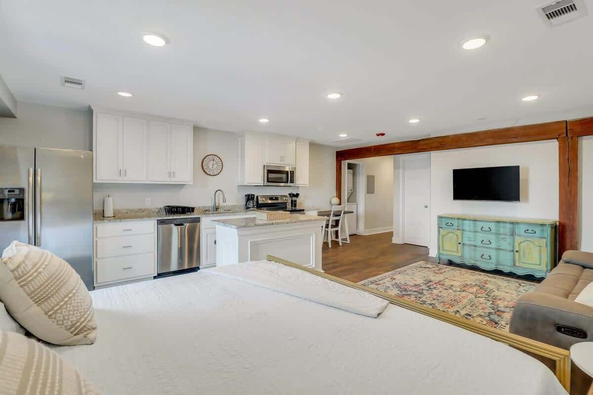 A modern kitchen with white cabinets, stainless steel appliances, and a central island.