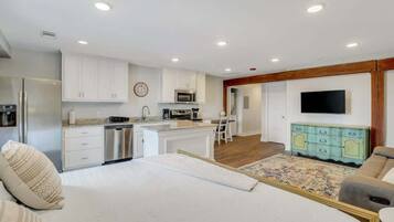 A modern kitchen with white cabinets, stainless steel appliances, and a central island.
