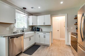 A modern kitchen with white cabinets, stainless steel appliances, and a granite countertop. - The Leaf Lodge - Walking Distance to MTSU 3Bed/2Ba (Murfreesboro)