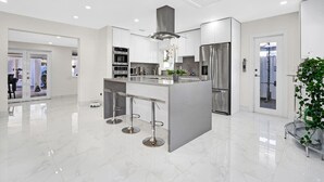 A modern kitchen with a central island, stainless steel appliances, and a bright, spacious layout.
