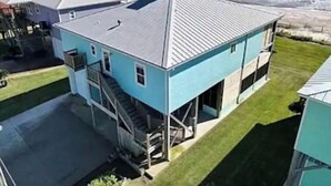 Et toetagers hus med blå facade, en synlig trappe og havudsigt.