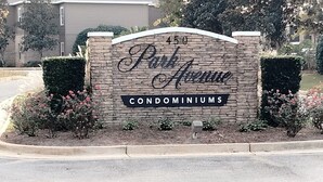 A sign for Park Avenue Condominiums with a brick wall and a landscaped area with bushes and flowers. - 2 BR/ 2BA Condo1 King /2 Full beds Sleeps 6 close to OWA & Foley Tourism Complex (Foley)