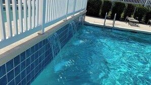 A swimming pool with clear blue water, a white fence, and a tiled edge. - 2 BR/ 2BA Condo1 King /2 Full beds Sleeps 6 close to OWA & Foley Tourism Complex (Foley)