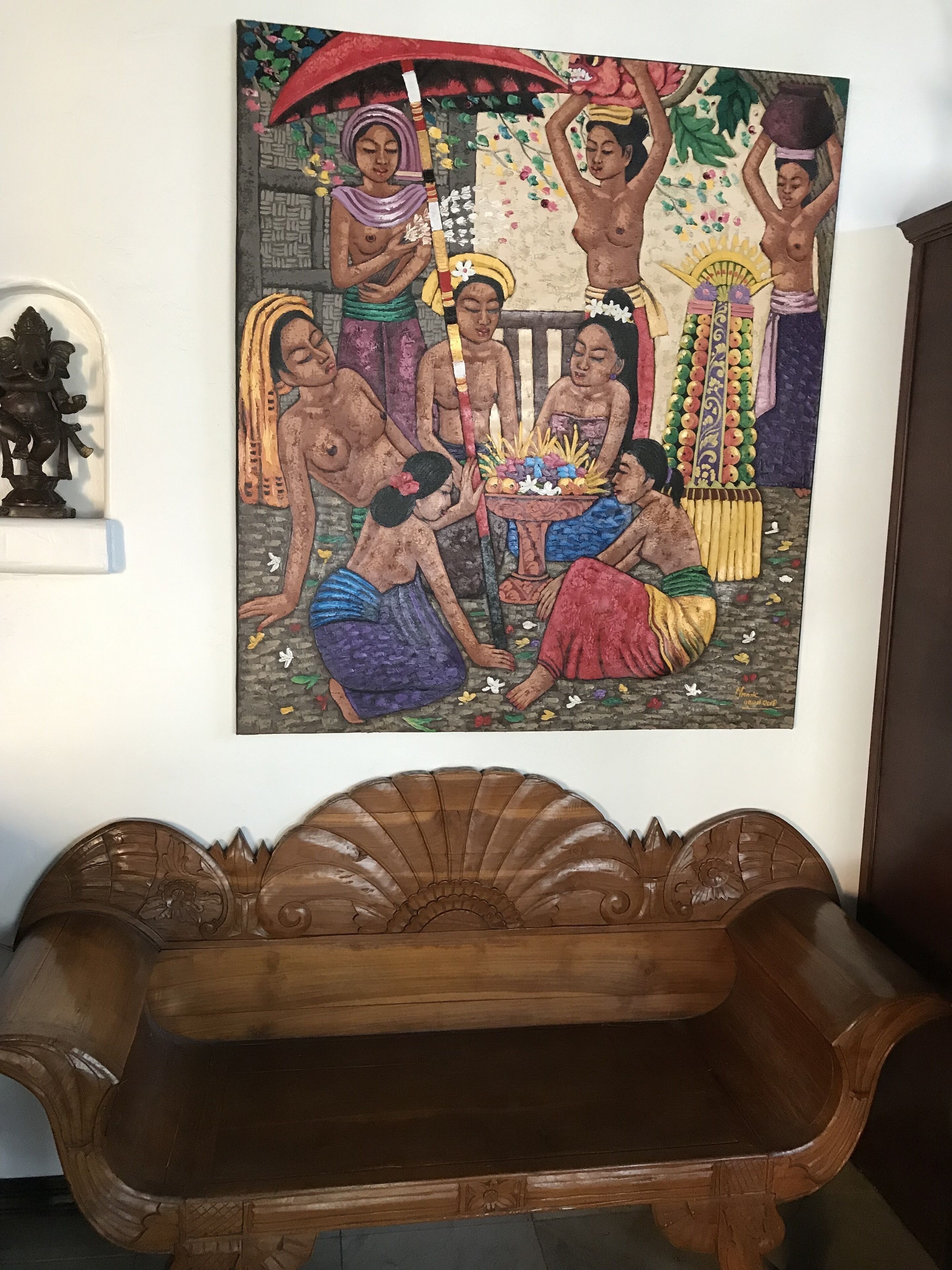 A wall-mounted painting of a traditional scene with figures and a musical instrument.