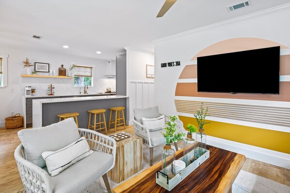 A modern living room with a sofa, a coffee table, and a TV mounted on the wall.