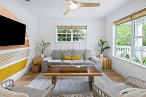 A modern living room with a sofa, coffee table, and potted plants.