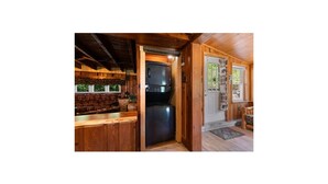 A compact kitchen with wooden cabinetry, a built-in oven, and a refrigerator. - Charming cottage overlooking pond and meadows (Holtwood)
