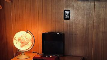 A wooden desk with a globe lamp, a typewriter, and a radio.