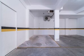 Eine Parkgarage mit weißen Wänden, gelb-schwarzen Streifen und Betonböden.