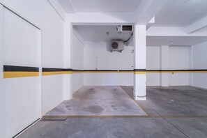 Eine Parkgarage mit weißen Wänden, gelb-schwarzen Streifen und Betonböden.