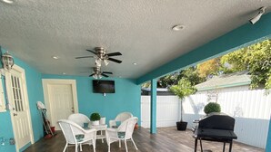 A covered patio area with a ceiling fan, a table with chairs, and a grill cart. - Hidden paradise close to downtown Tampa (Tampa)
