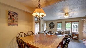 A dining area with a wooden table and chairs, a ceiling fan, and a poster on the wall. - Rare Gem, Spacious Condo, Outstanding Location A6 (Copper Mountain)