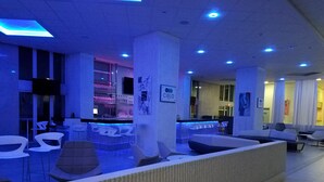 Un espace bar moderne, doté de sièges et d’un comptoir.