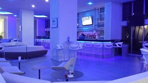 A modern lounge area with white sofas and chairs, a bar with a TV, and a pool table. - Beach HotelCndo 1562 (Carolina)