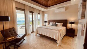 Een ruime slaapkamer met een groot bed, een stoel en uitzicht op de omgeving.