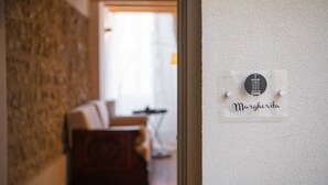 A hallway with a stone wall and a sign reading "Margherita." - Margherita (Roè Volciano)