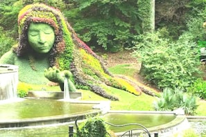 Stunning sculpture surrounded by lush greenery and a serene water feature.