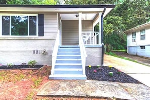 Stroll up to the charming entrance, where a beautifully landscaped garden and a welcoming porch await.
