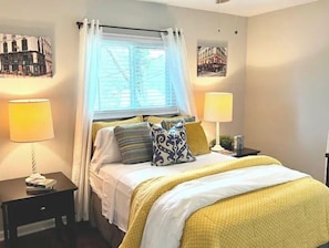 Cozy retreat with a large bed, two bedside tables, and framed artwork adorns the walls.