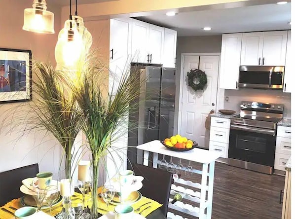 Enjoy meals in the kitchen with a dining area for two, featuring a table and a vase with greenery.