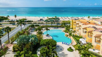 A resort with a swimming pool, beach, and ocean view.