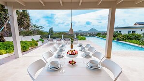 An outdoor dining area with a view of a pool and mountains. - Sombre 14-e (Santa Cruz)