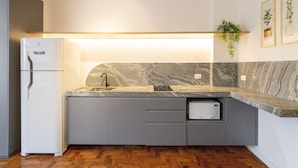 Una cocina moderna con refrigerador incorporado, microondas y pileta.